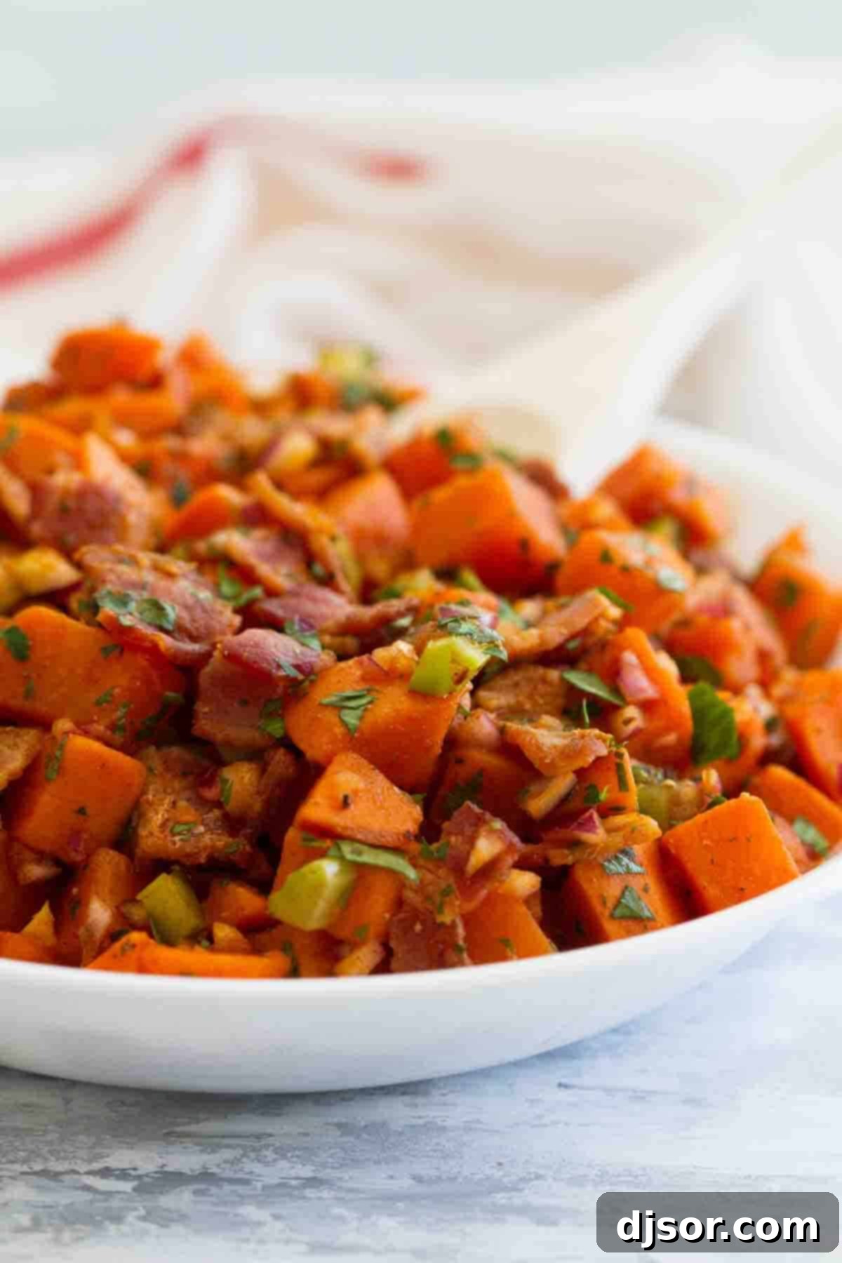 Sweet Potato Salad with Bacon: A Tangy German-Inspired Side A vibrant bowl filled with Sweet Potato Salad with Bacon, garnished with fresh herbs, ready to be served.