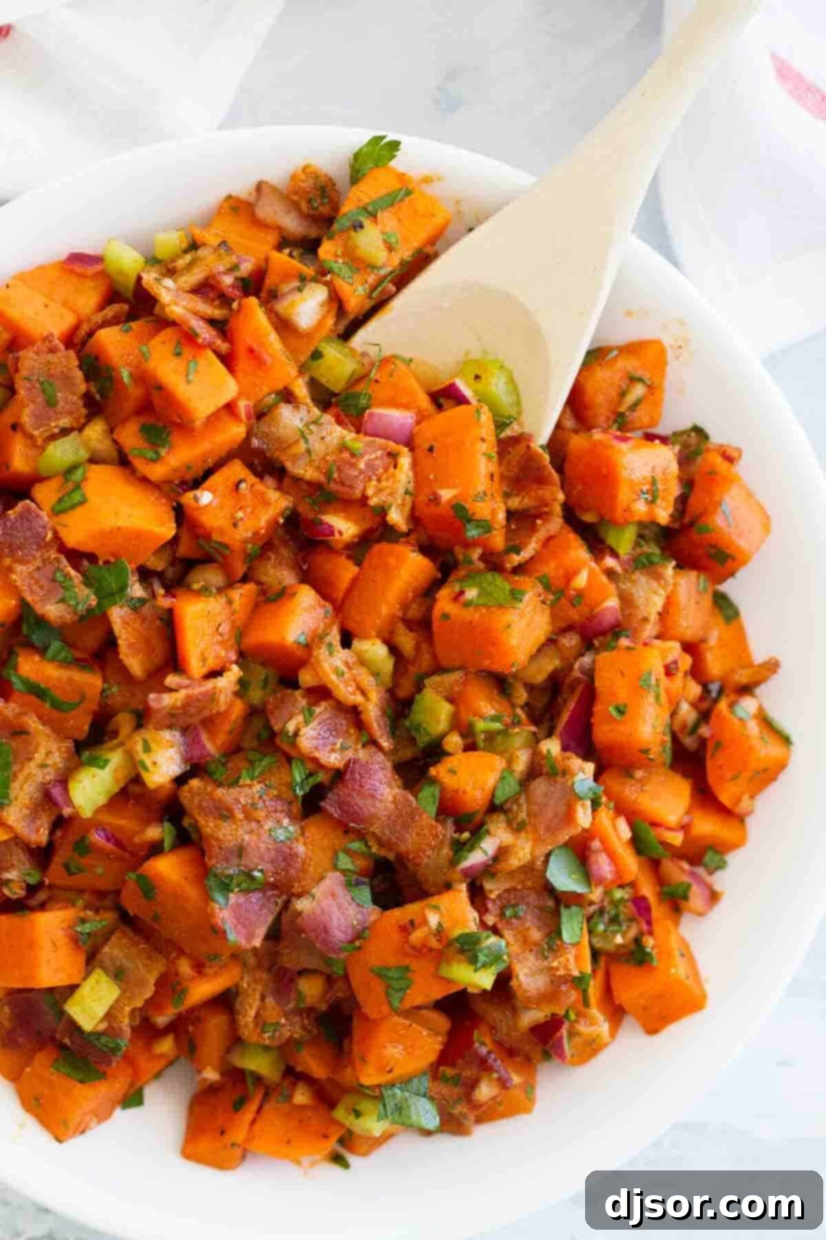 Savory Sweet Potato Salad with Bacon Delicious potato salad made with sweet potatoes and crispy bacon bits, served in a rustic bowl.