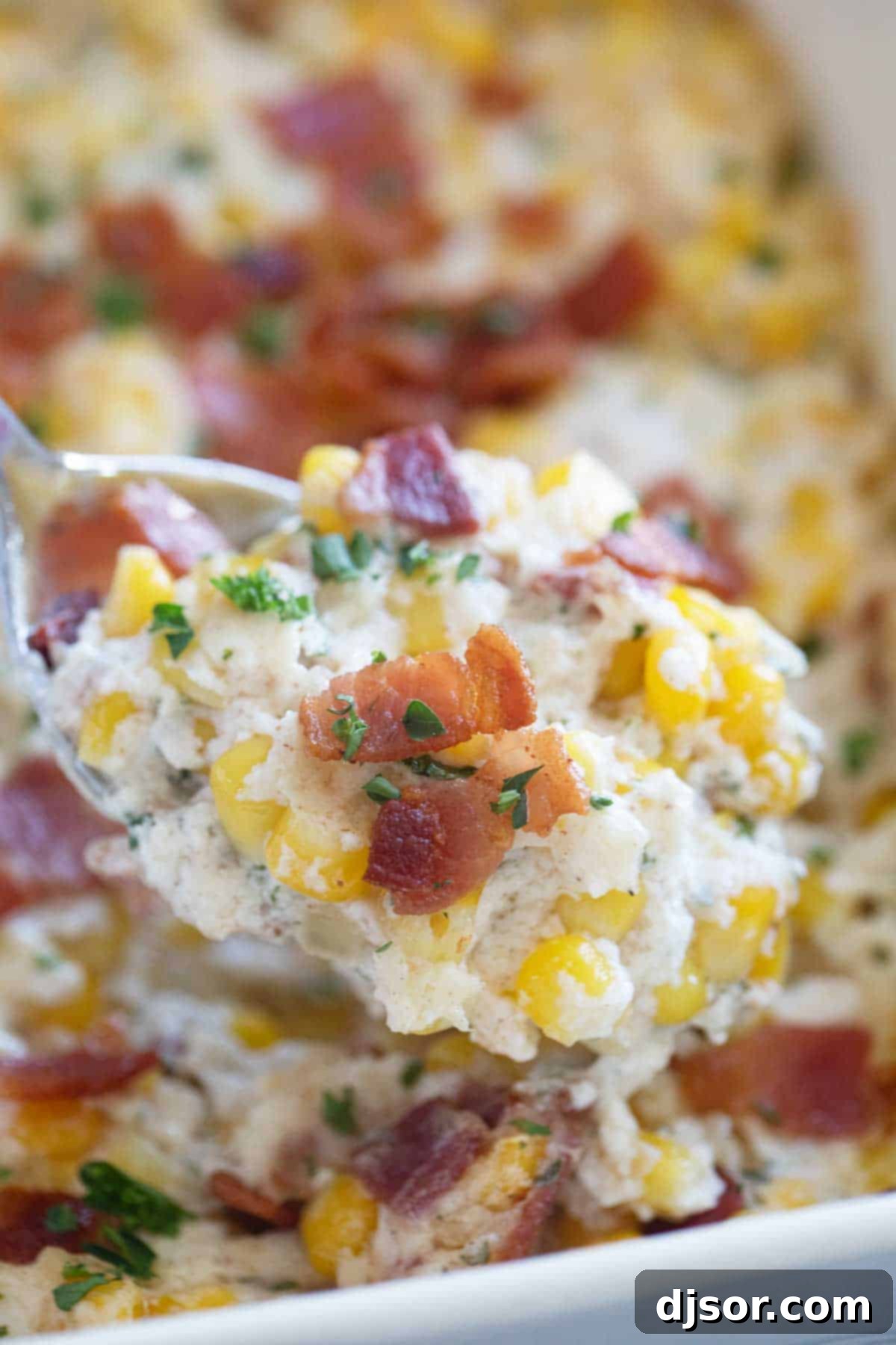 Velvety Corn and Bacon Bliss 8 A serving spoon lifting a generous scoop of hot, creamy corn and bacon from the casserole dish, showing off its rich texture.