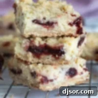 Three Cranberry Cheesecake Bars stacked on top of each other.