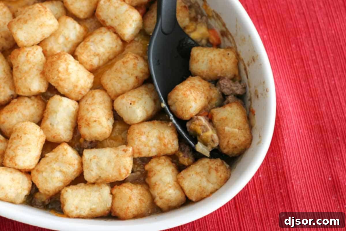 Tater Tot Shepherd's Pie 2 Shepherd's Pie with Tater Tots with a serving spoon, showcasing the crispy topping and savory filling