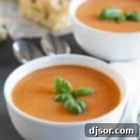Vibrant Tomato Basil Soup 2 Two bowls of tomato basil soup topped with fresh basil.