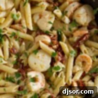 Key West Sunset Penne 2 A pan full of Key West Penne, showcasing pasta with shrimp, scallops, and sun-dried tomatoes.