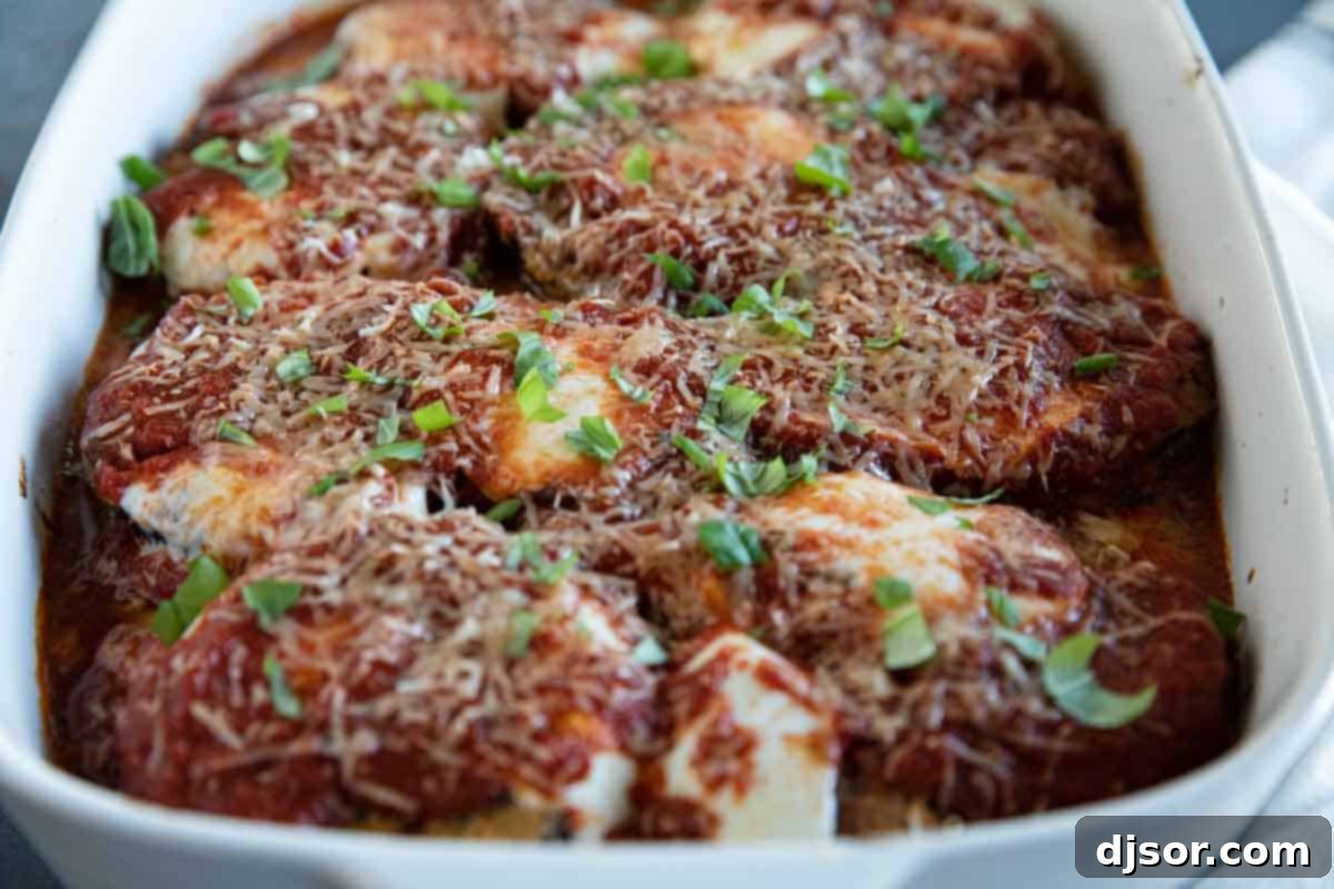 Breaded slices of eggplant, lots of cheese, and marinara sauce make up this Eggplant Parmesan that the whole family will love. view of eggplant parmesan in a casserole dish.