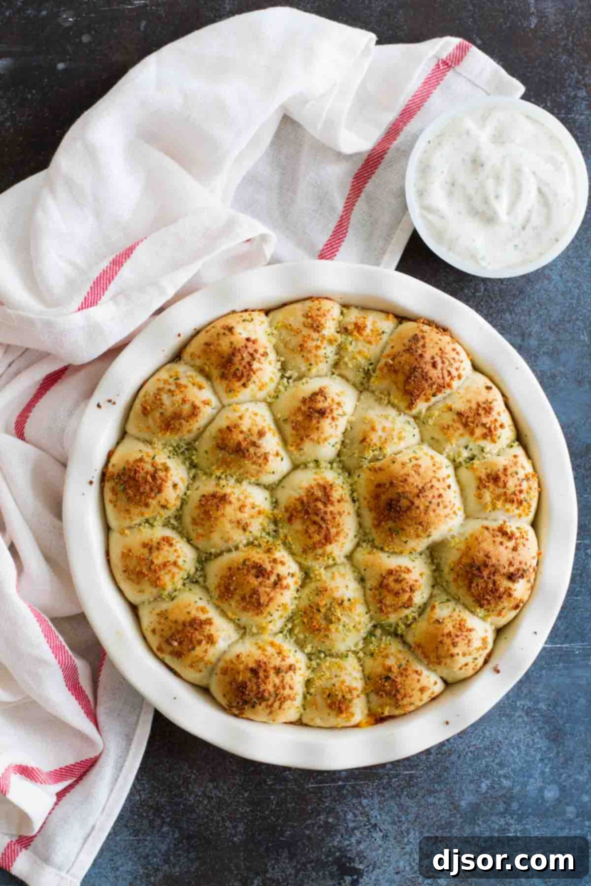 Stuffed Pizza Rolls in a baking dish, with a small bowl of creamy ranch dressing for dipping next to them.