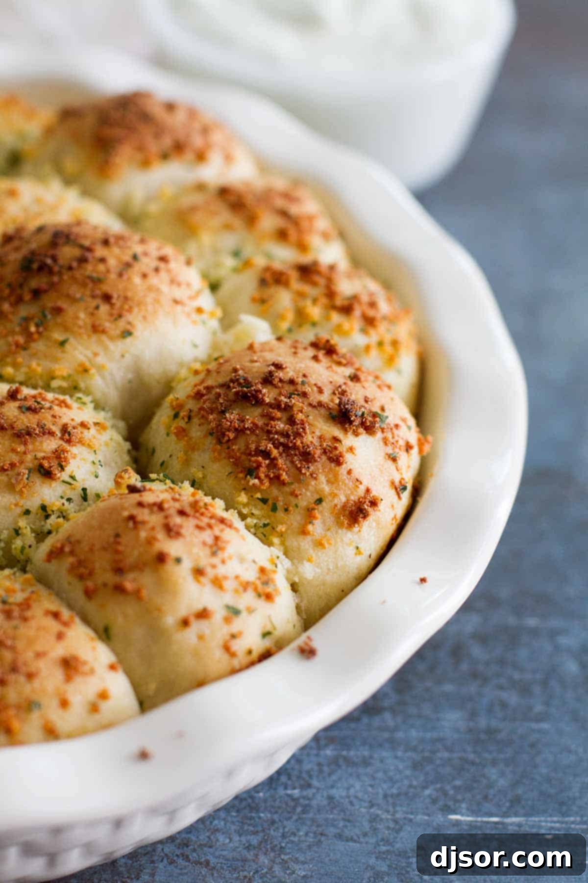 Close-up view of the golden-brown topping, a mix of melted butter, ranch seasoning, and Parmesan cheese, on the baked stuffed pizza rolls.