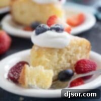A close-up shot of a slice of Lemon Yogurt Cake on a plate, with a fork holding a perfect bite of the moist cake, highlighting its delicate texture.