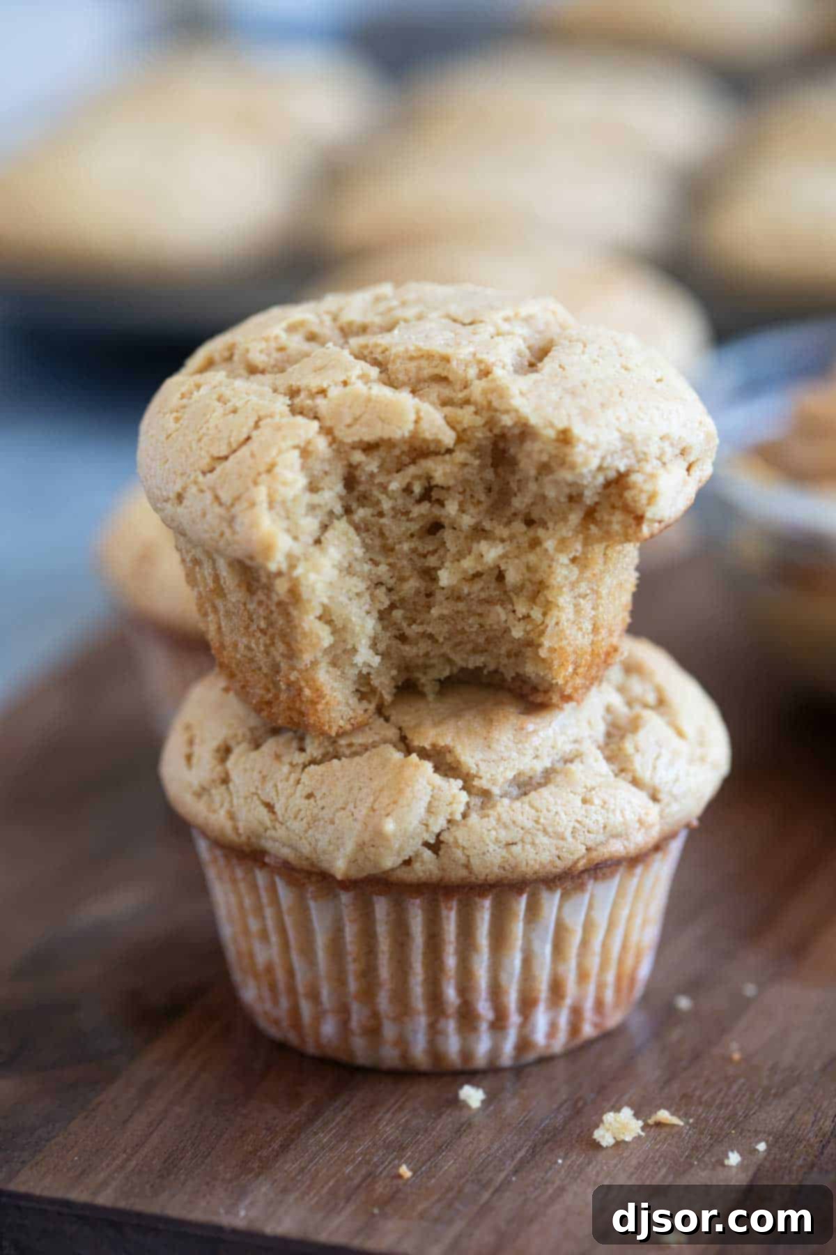 Irresistible Peanut Butter Muffins 9 Two peanut butter muffins stacked, with a bite taken from the top muffin.