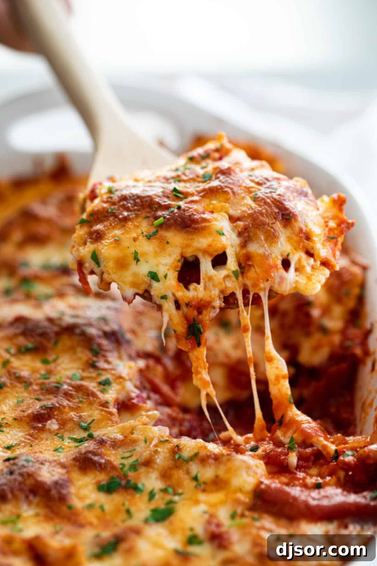This Baked Ravioli recipe takes frozen ravioli and combines it with a homemade pasta sauce and lots of cheese. It’s super easy and super filling! Spoonful of Baked Ravioli with Melted Cheese