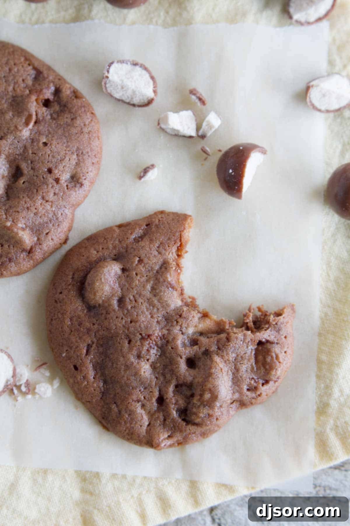 A Chocolate Malt Whopper Drop cookie with a bite taken out, revealing the soft interior and chocolate chunks.