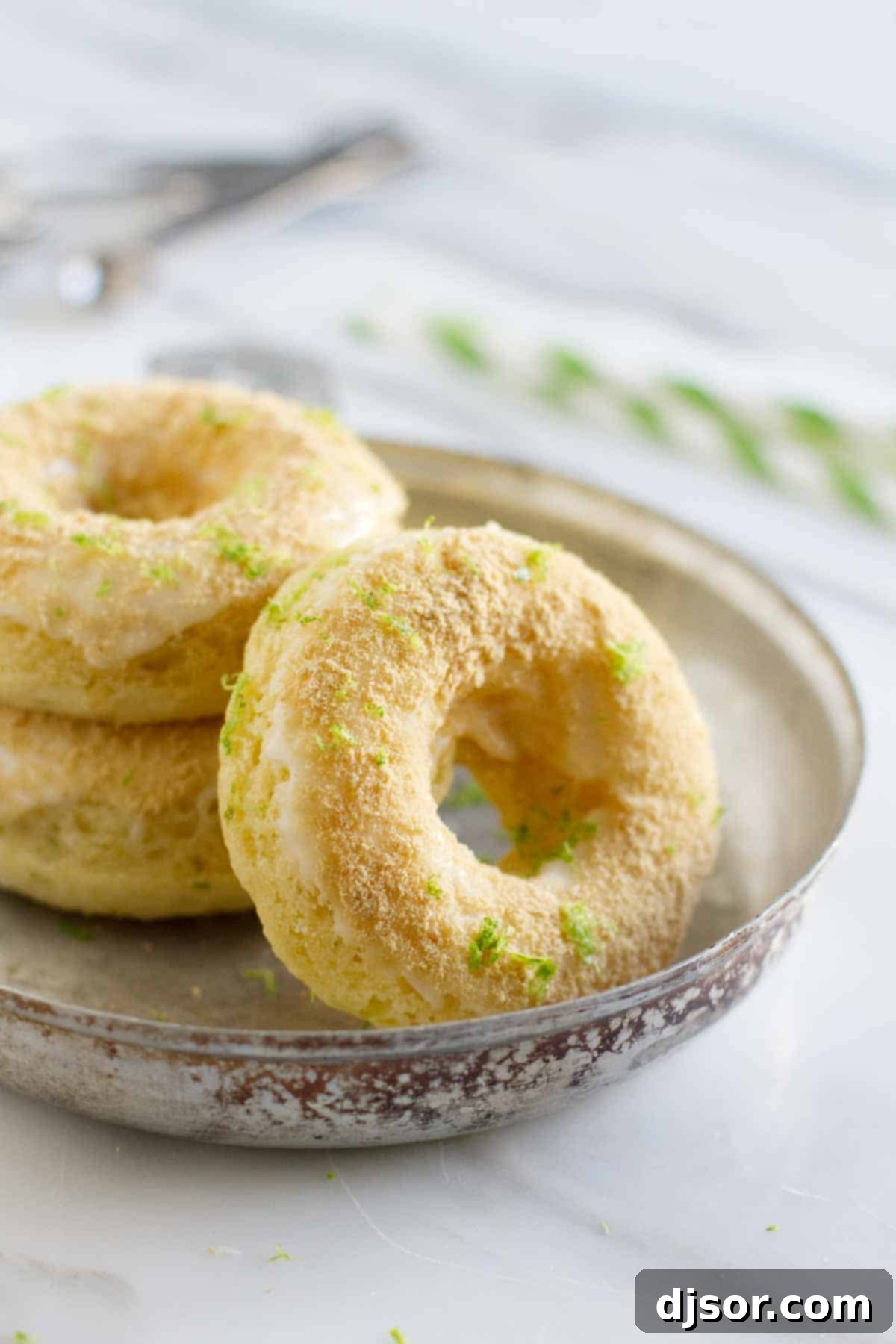 Baked Key Lime Pie Donuts in a dish, showcasing their vibrant green glaze and graham cracker topping.