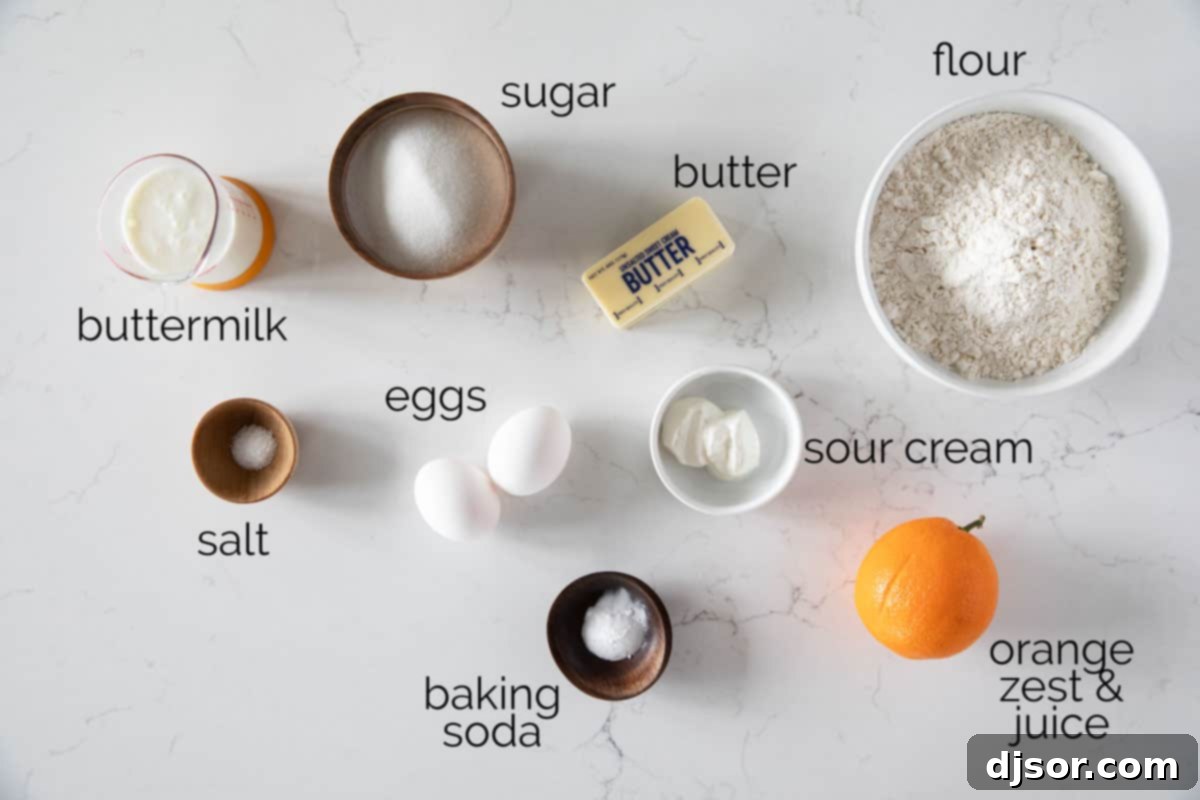 These Orange Muffins are moist and flavorful, slightly sweet with an orange simple syrup for the perfect finishing touch. A curated display of fresh ingredients essential for making the most delicious Orange Muffins, including oranges, eggs, butter, and flour.