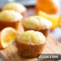 Zesty Orange Muffins 2 Orange muffins with an orange simple syrup on a wooden board.