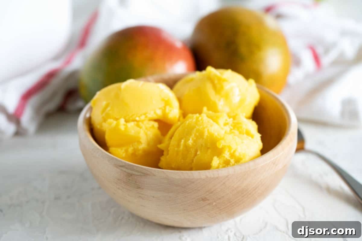 Fresh mangoes and lime juice come together to make a perfectly tropical Mango Sorbet. bowl with scoops of Mango Sorbet