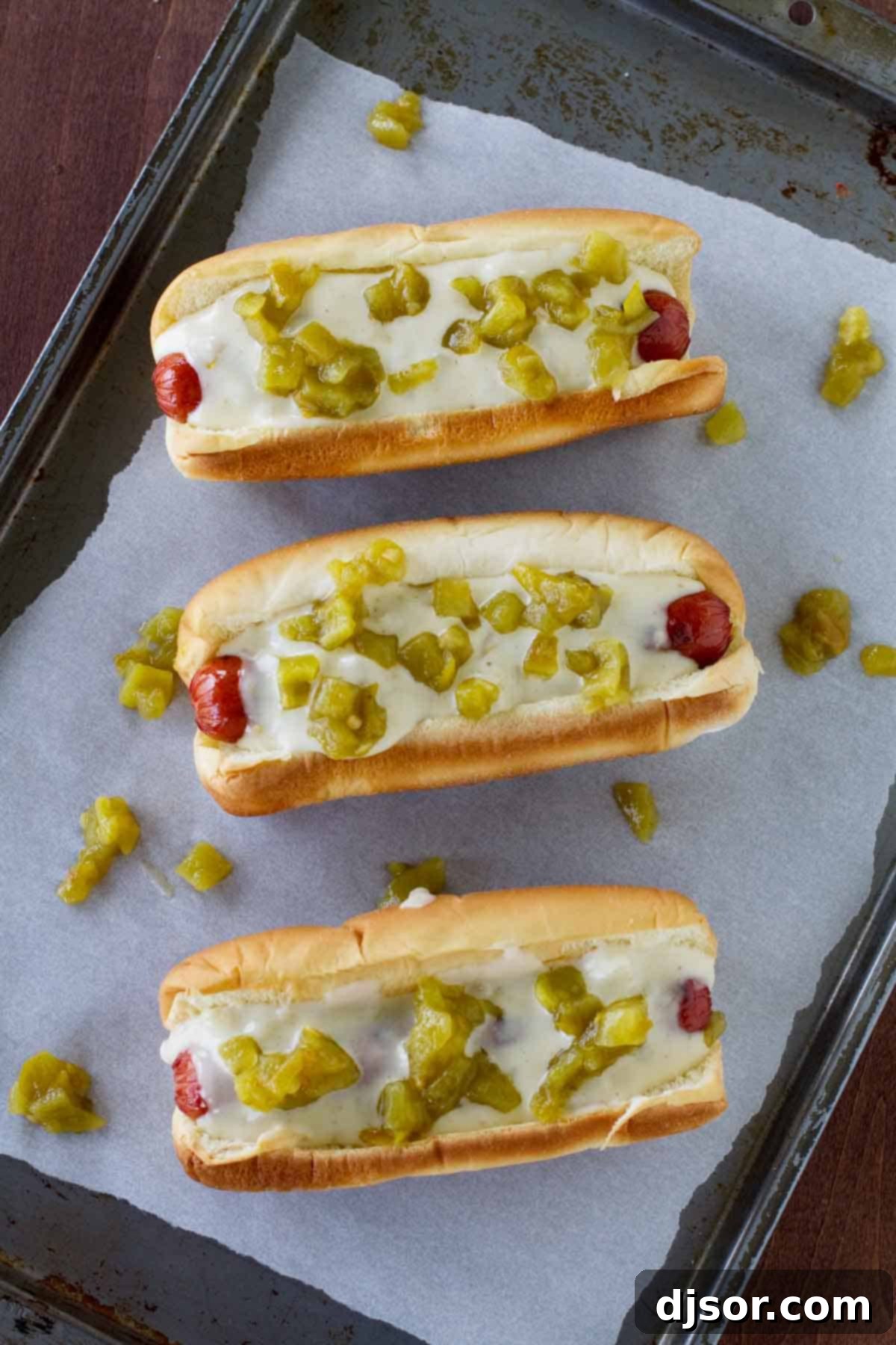 Green Chile Hot Dogs on parchment paper on a baking sheet.
