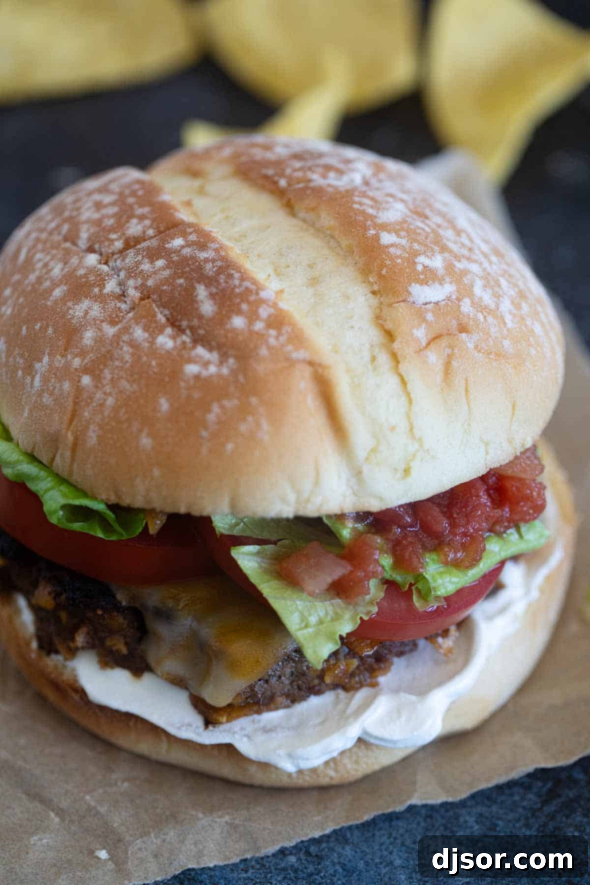 Fiesta Burgers 7 Taco burger on a piece of parchment paper.
