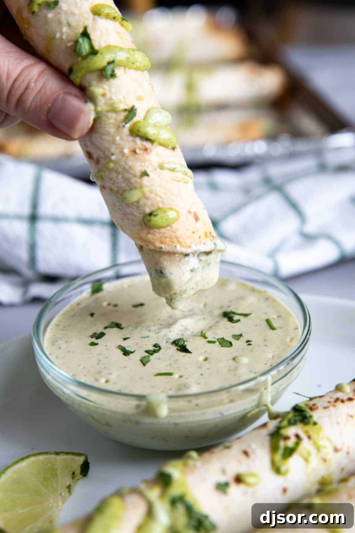 Crispy Chicken Flautas 9 Dipping a chicken flauta into cilantro ranch sauce.