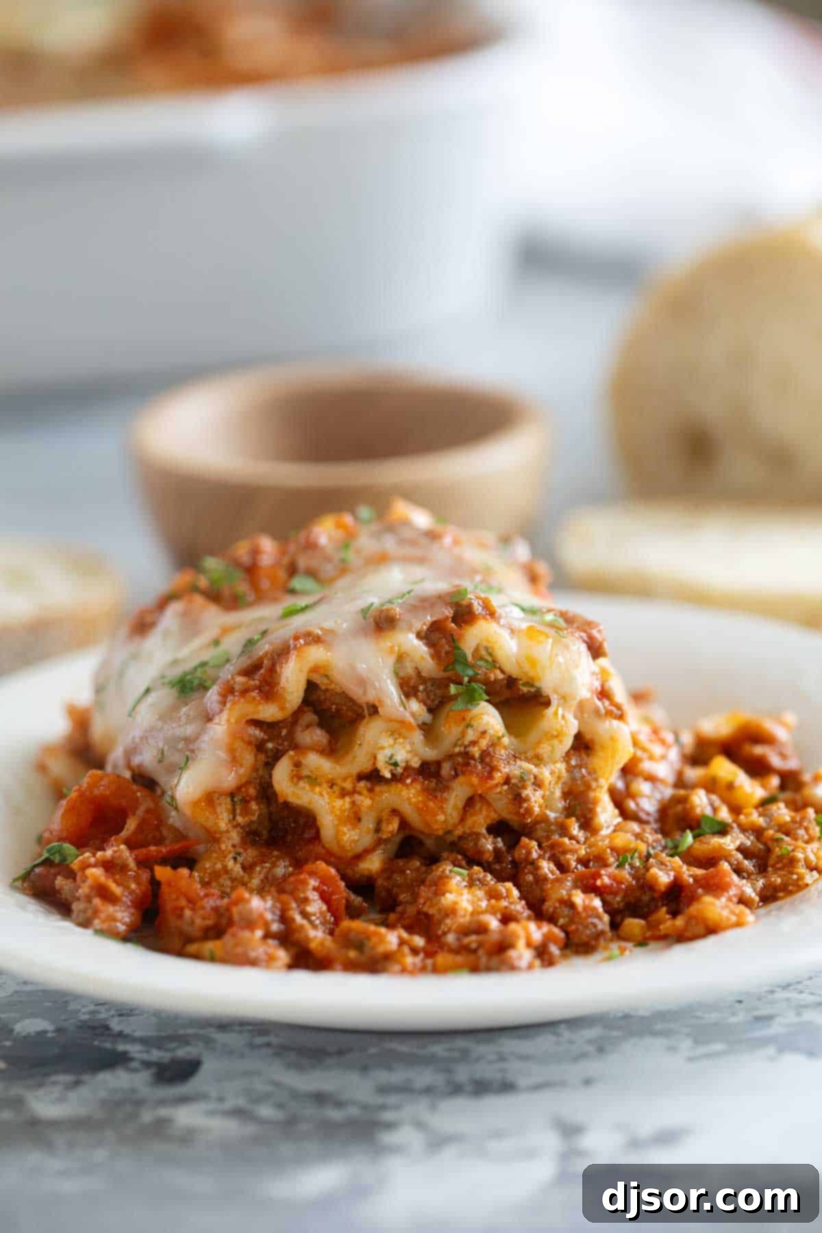 Easy Lasagna Pinwheels 10 A single Lasagna Roll Up served on a white plate, garnished with fresh chopped parsley, highlighting its vibrant colors and delicious appeal.