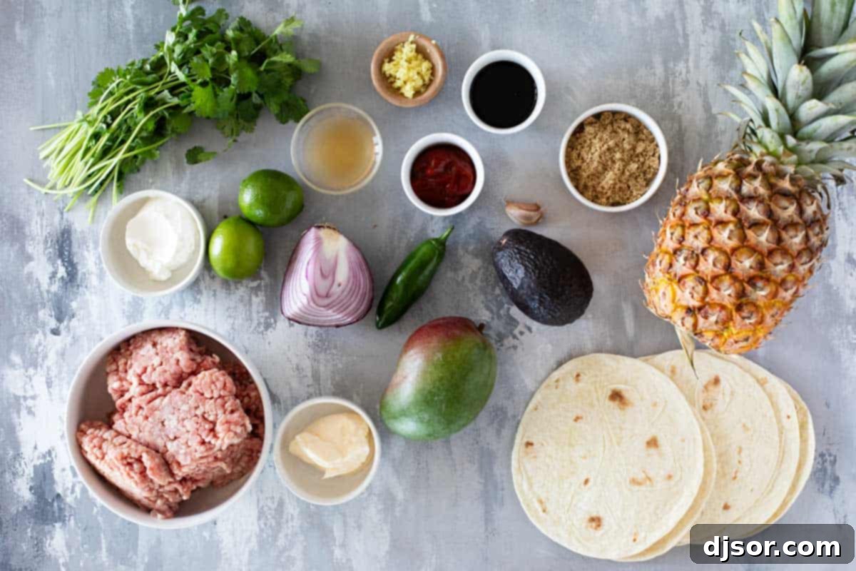 Island Taco Fiesta 3 Ingredients for Hawaiian Tacos laid out on a wooden board: fresh pineapple, mango, avocado, ground pork, cilantro, lime, sauces, and spices.