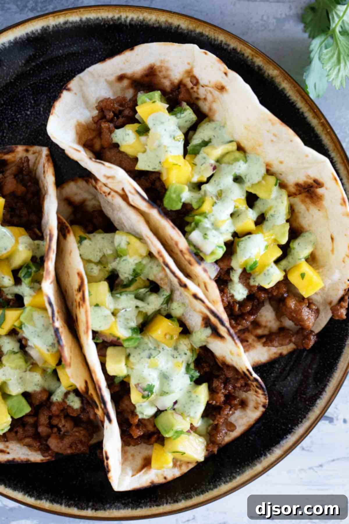 Island Taco Fiesta 7 A close-up shot of Hawaiian Tacos, showcasing the perfectly seasoned ground pork, fresh salsa, and luscious cilantro lime sauce.
