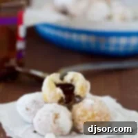 Chocolate Hazelnut Stuffed Donut Holes stacked on top of each other with one broken open.