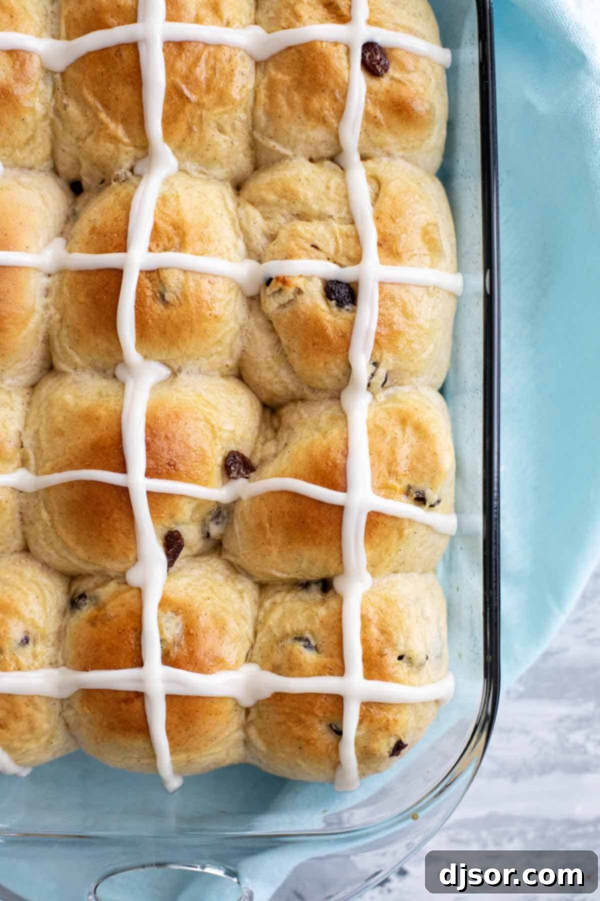 Golden Brown Hot Cross Buns with Icing Overhead view of several Hot Cross Buns arranged on a wooden surface, showcasing their golden brown tops and delicate icing crosses.