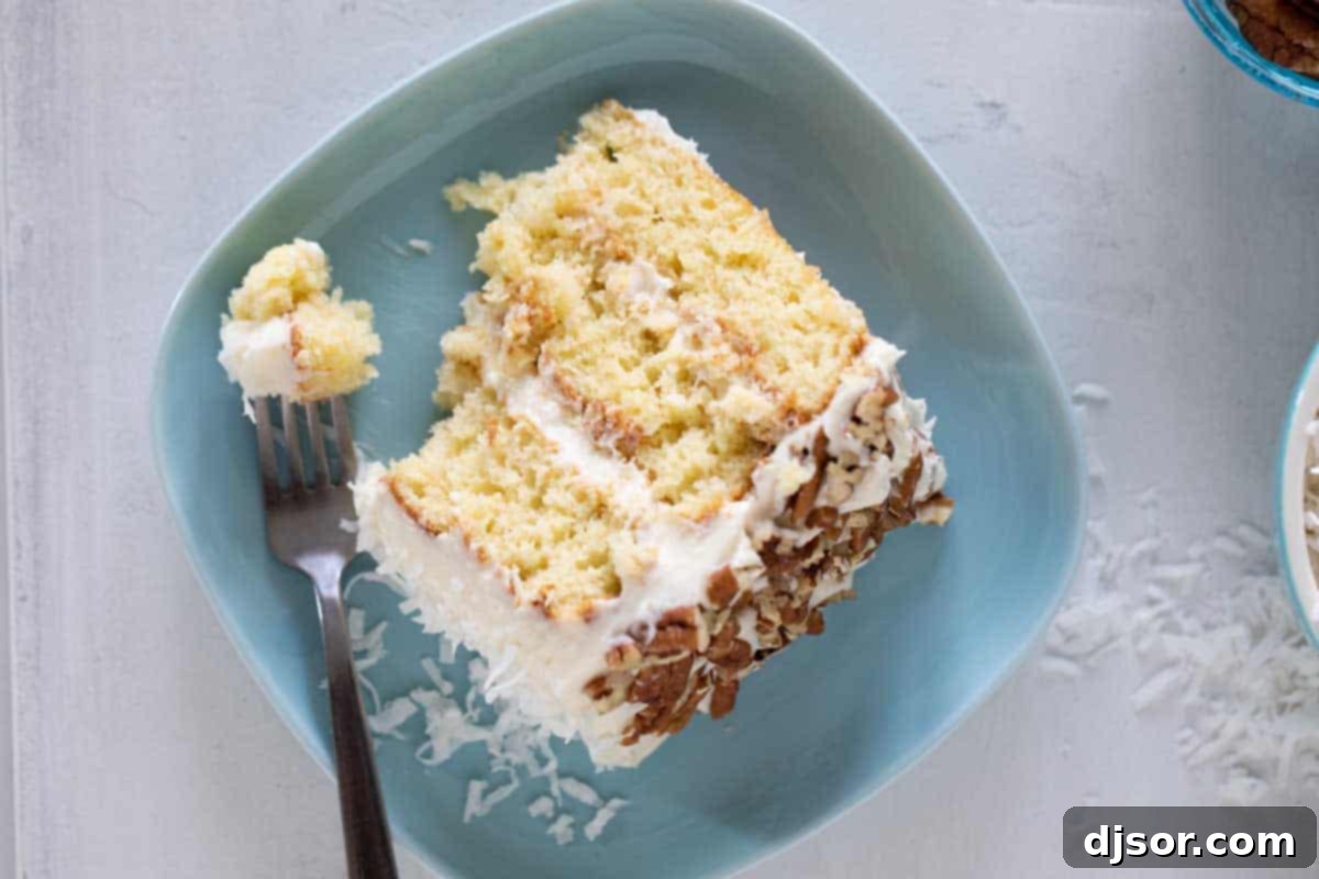 A mouth-watering slice of Italian Cream Cake ready to be enjoyed. slice of Italian Cream Cake on a blue plate with a fork taking a bite