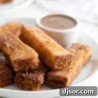 French Toast Sticks 2 French Toast Sticks with buttermilk syrup in the background for dipping.