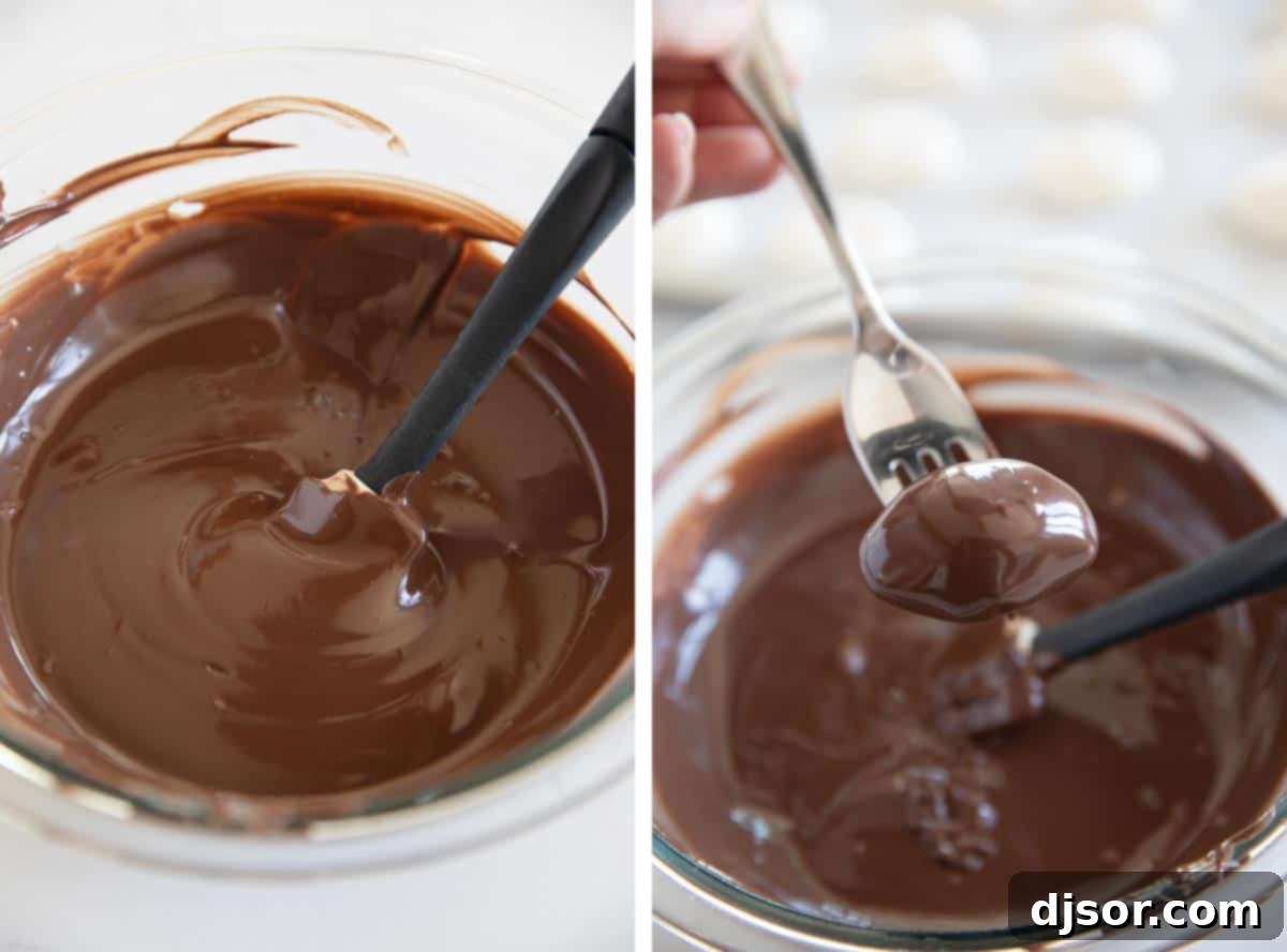Dipping and Decorating Chocolate Truffles A close-up view of hands carefully dipping a frozen marshmallow egg into a bowl of smooth, melted chocolate, showing the rich coating process, with some dipped truffles already sitting on parchment paper.
