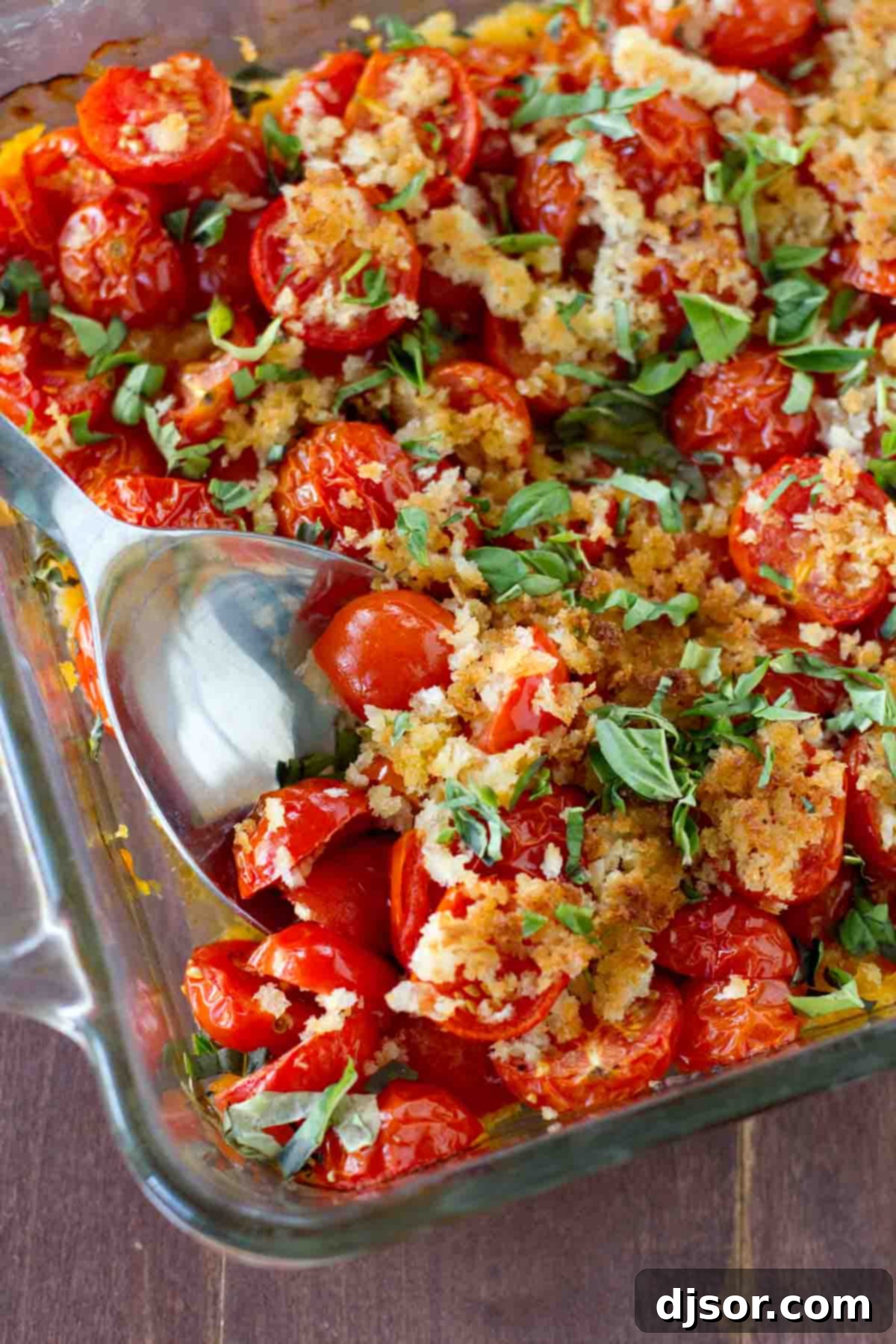 A vibrant baking dish filled with roasted cherry tomatoes and fresh basil, ready to be served as a delicious side.