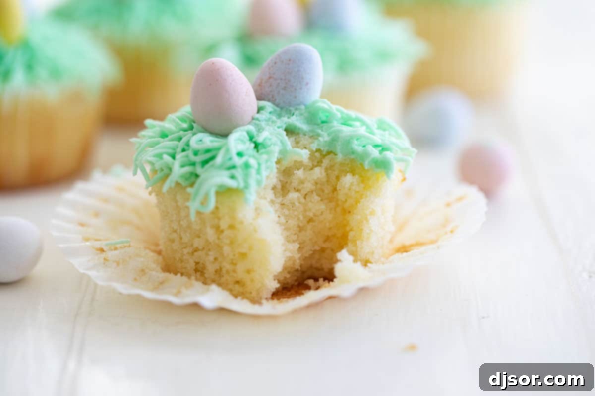 Easter cupcake with a bite taken from it, showing the soft, moist interior of the lemon cake.