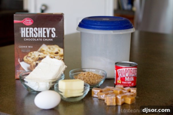 Ingredients for Caramel Cookie Cheesecake Bars laid out on a table.