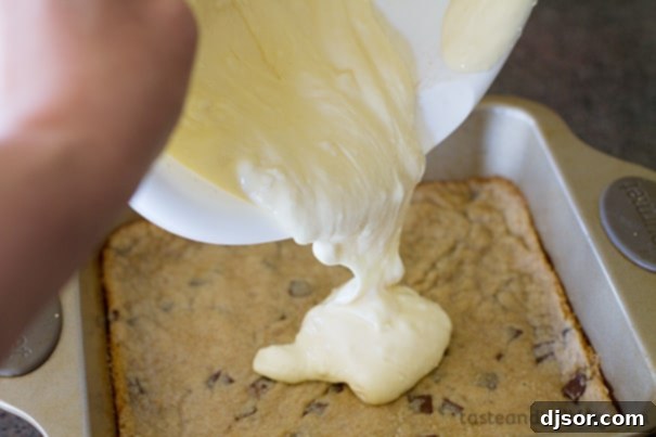 Pouring cheesecake batter over a baked cookie base.