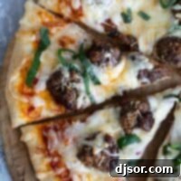 Ultimate Meatball Pizza 2 Meatball pizza cut into slices, topped with fresh basil.