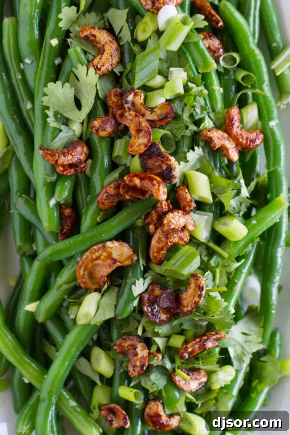 Close-up view of the Fresh Green Bean Salad, showcasing the perfectly blanched green beans, vibrant cilantro, and chopped green onions, all coated in the flavorful Asian dressing.