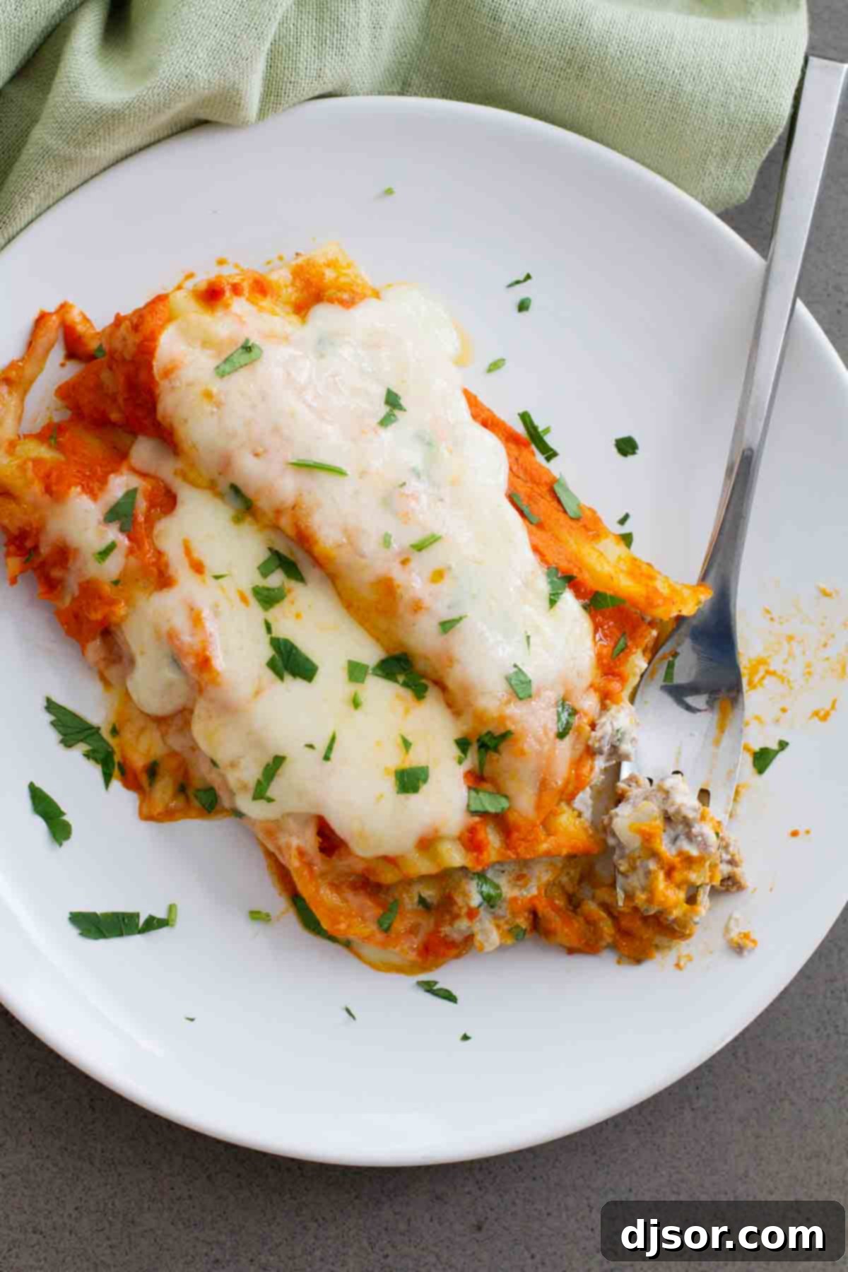 Person taking a bite of Ground Beef Stuffed Manicotti