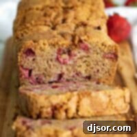 full loaf of strawberry bread cut on a cutting board.