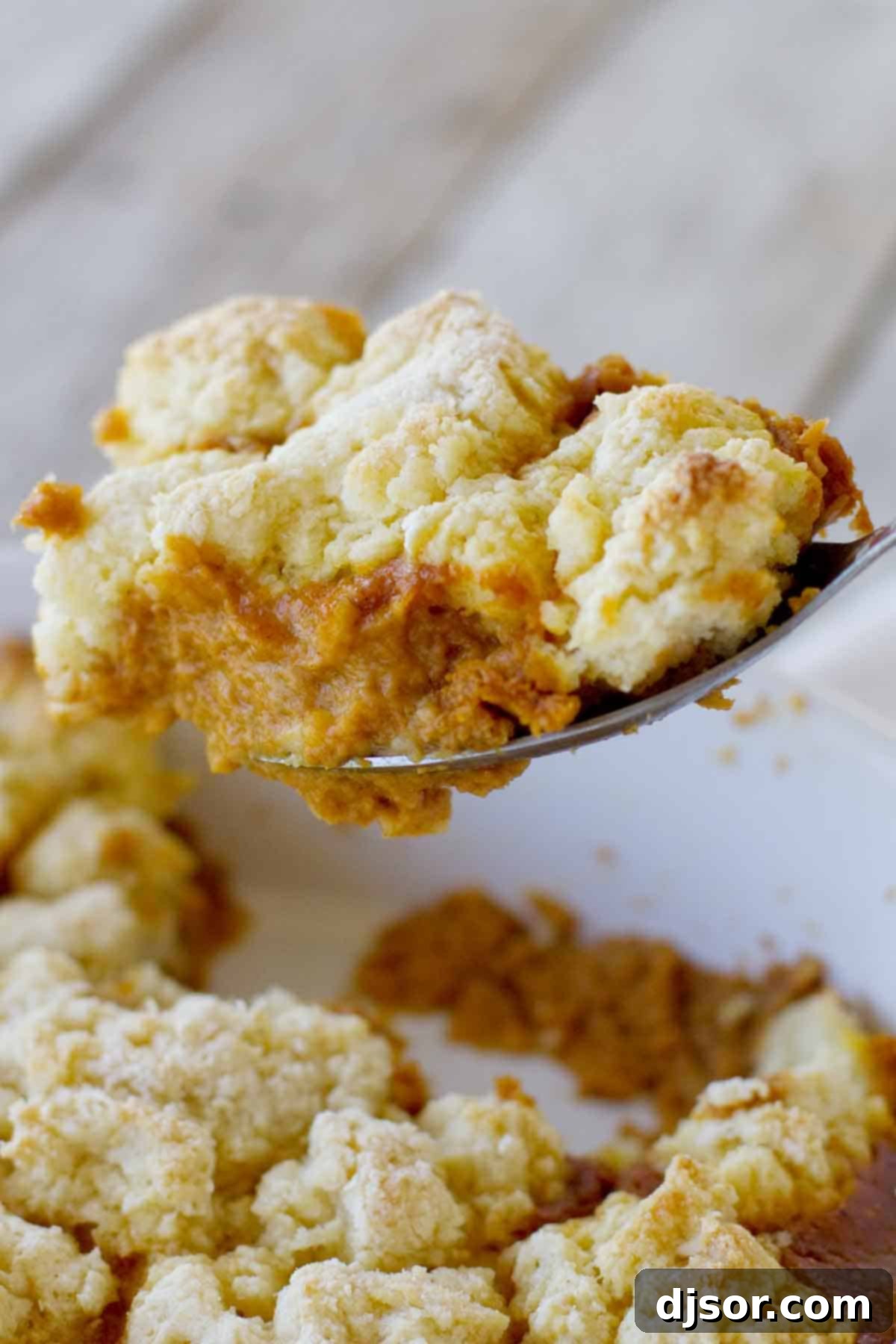 Spoon with scooping out a portion of Pumpkin Cobbler.