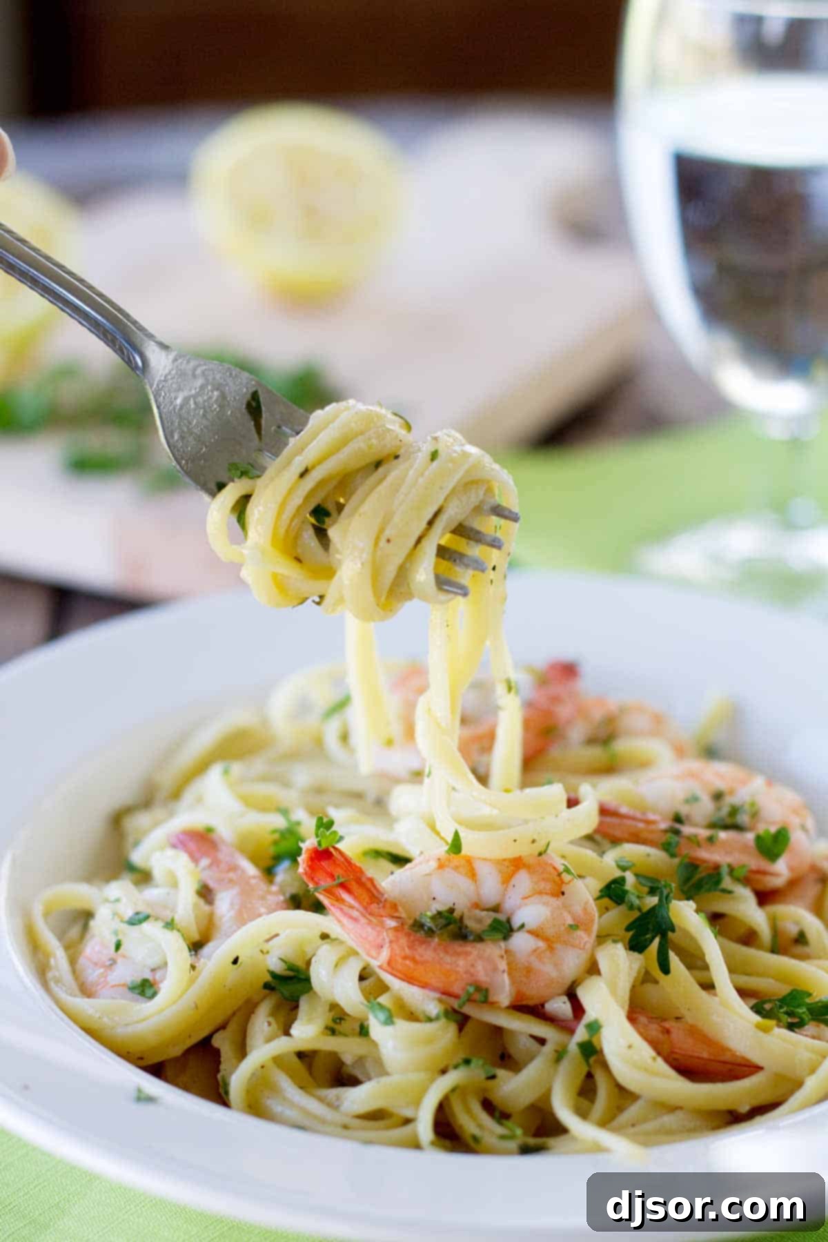 A restaurant worthy meal, this Lemon Pepper Shrimp Pasta is easy to prepare yet impressive and delicious! Close-up of pasta dish with perfectly cooked lemon pepper shrimp and fresh parsley.