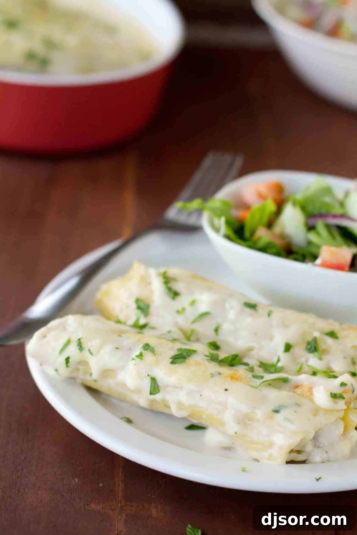 Serve up a delightful Chicken Manicotti with Mushrooms for a comforting and satisfying meal. A serving of Chicken Manicotti with Mushrooms on a plate, garnished with parsley, with a fresh side salad in the background.