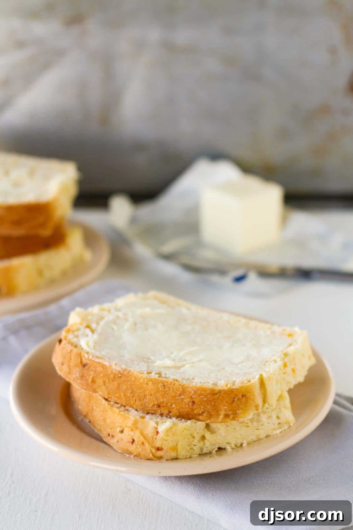 Two slices of warm, freshly baked Green Chile Cheddar Bread on a rustic plate, ready to be enjoyed.