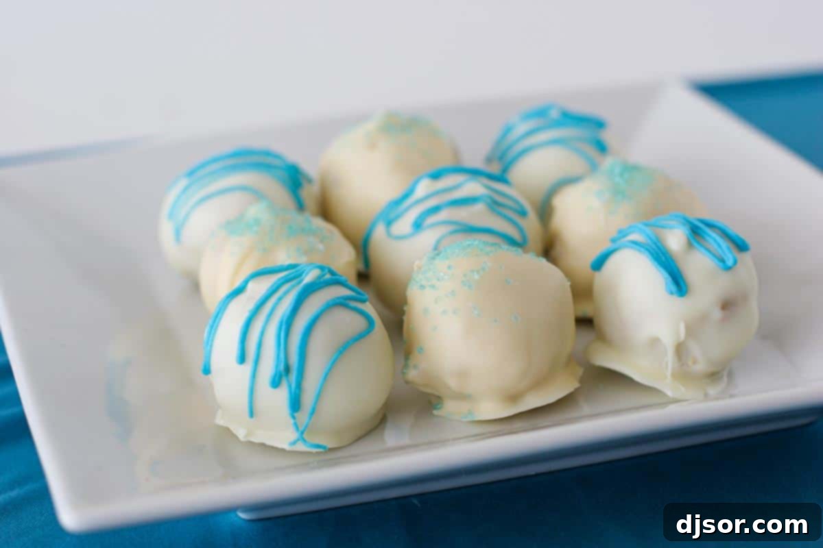 A plate of nine perfectly round Coconut Cake Truffles, garnished with shredded coconut, against a light background.