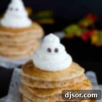 Phantom Spice Flapjacks 2 Stack of spiced ghost pancakes with a whipped cream ghost on top, ready for a Halloween feast.