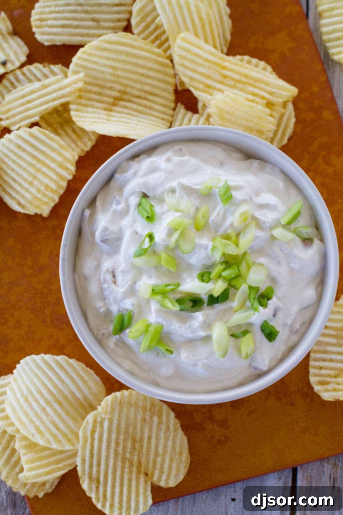 Homemade Bacon Horseradish Dip with Potato Chips Overhead shot of a generously sized bowl of creamy Bacon Horseradish Dip, surrounded by crispy potato chips, perfect for sharing at parties.