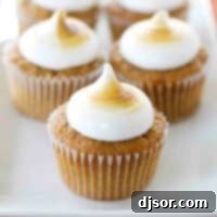 Cozy Sweet Potato Cupcakes with Torched Mallow Swirls 5 A plate full of Sweet Potato Cupcakes that are topped with toasted marshmallow frosting.