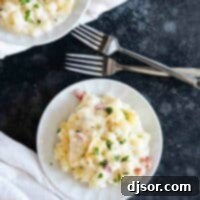 plates with crockpot cheesy potatoes and forks.