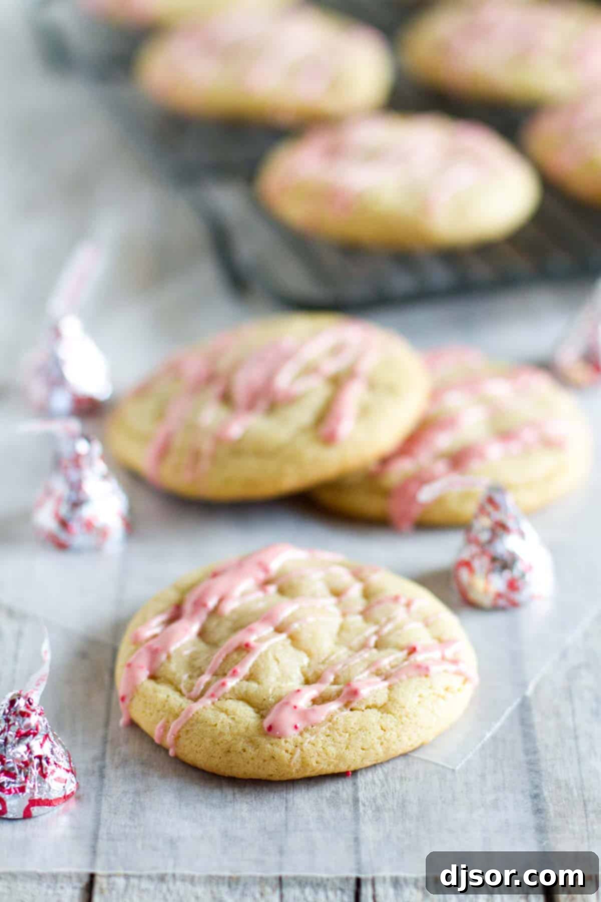 Super soft peppermint cookies stuffed with Candy Cane Kisses and drizzled with melted peppermint chocolate.
