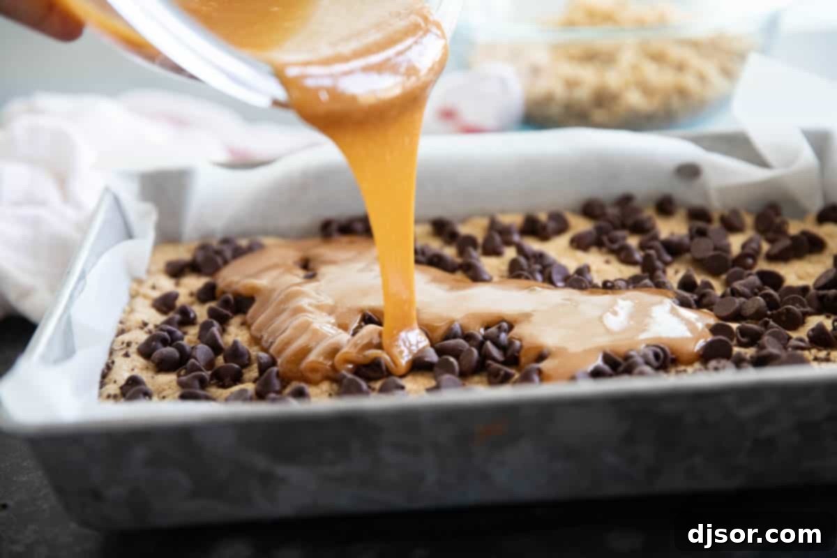 Pouring caramel over chocolate chips for Carmelitas.