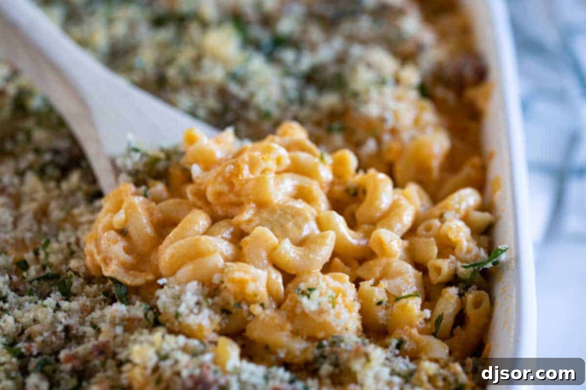 wooden spoon full of Buffalo Chicken Mac and Cheese in a baking dish