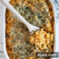 overhead view of a casserole dish of Buffalo Chicken Mac and Cheese with a wooden spoon